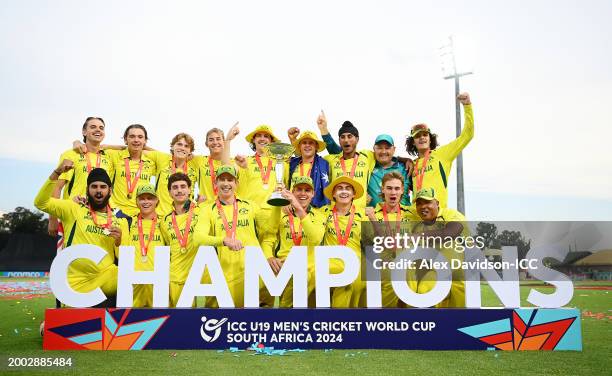 Hugh Weibgen, Captain of Australia, and Harry Dixon lift the ICC U19 Men's Cricket World Cup trophy as players of Australia pose for a team...