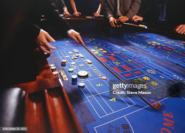 people playing craps in casino, croupier collecting chips - クラップス ストックフォトと画像