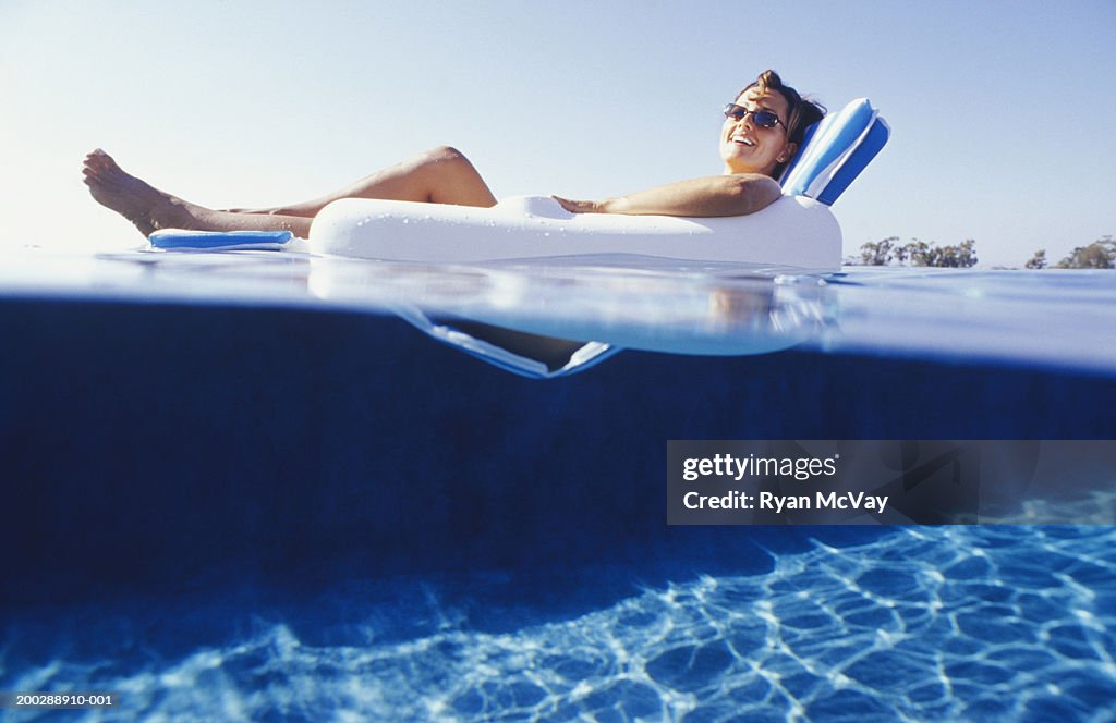Woman lying in floating chair, surface view