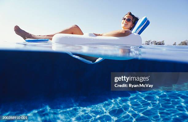 woman lying in floating chair, surface view - pool raft imagens e fotografias de stock