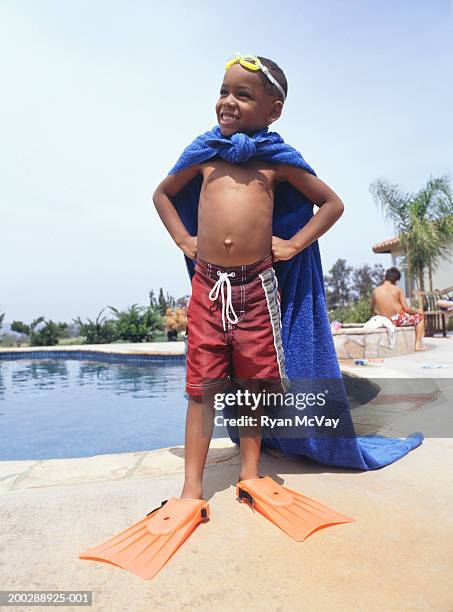 boy (4-5) wearing towel as cape, standing by pool - boy in swimwear stock-fotos und bilder