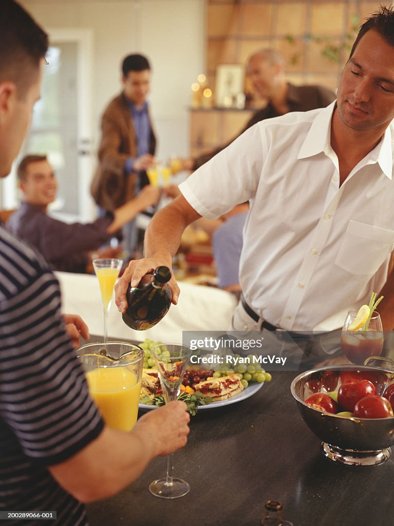 Man pouring wine at birthday party