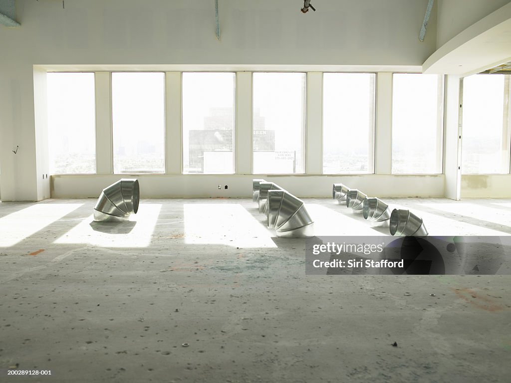 Aluminum tubes on floor of  empty office space