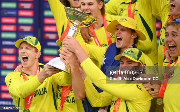 Hugh Weibgen, Captain of Australia, and Harry Dixon lift the ICC U19 Men's Cricket World Cup trophy as players of Australia celebrate after the ICC...