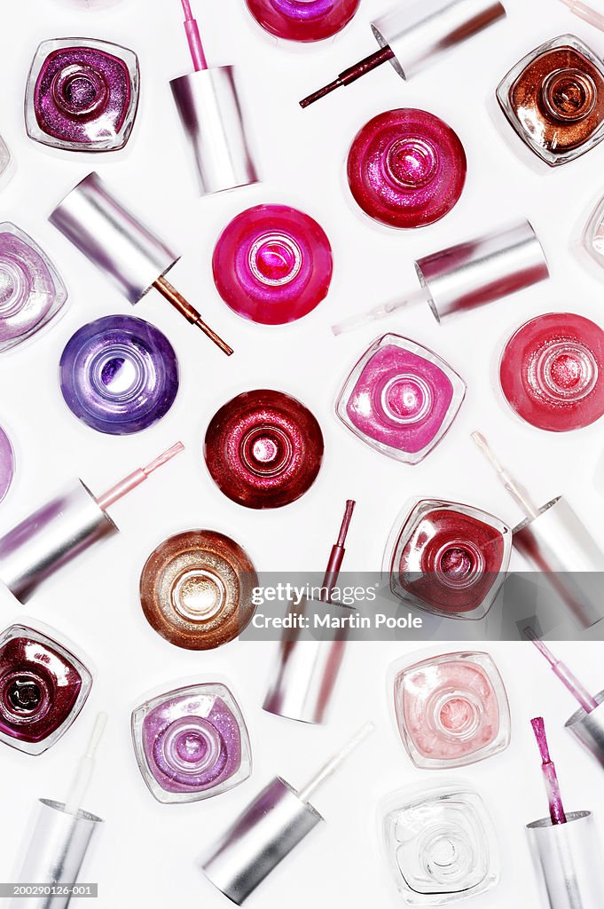 Assortment of nail varnish bottles and lids, elevated view