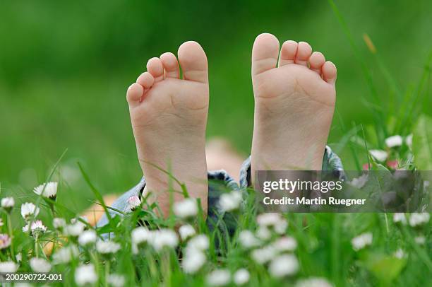 girl (3-5) lying on grass, close-up of feet - barefoot feet up lying down girl stockfoto's en -beelden