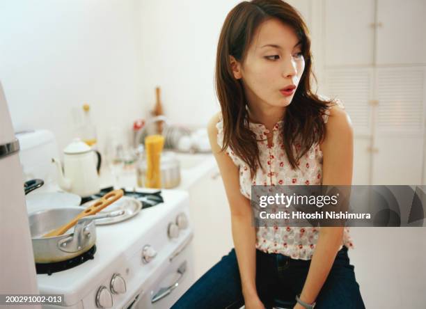 woman in kitchen, looking away - whistling stock pictures, royalty-free photos & images