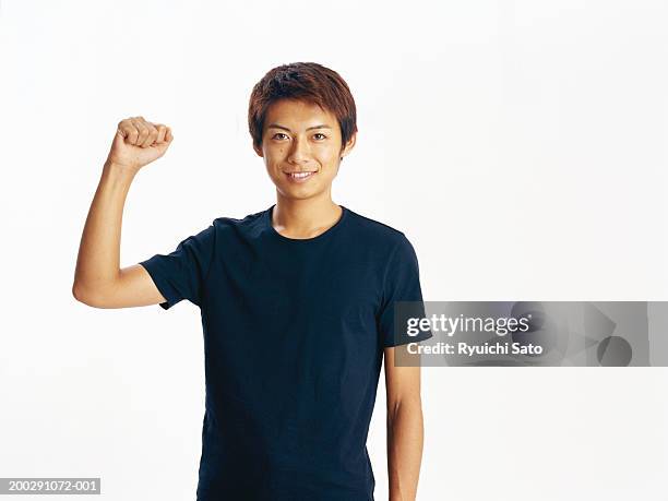 young man smiling, punching the air, portrait - manga corta fotografías e imágenes de stock
