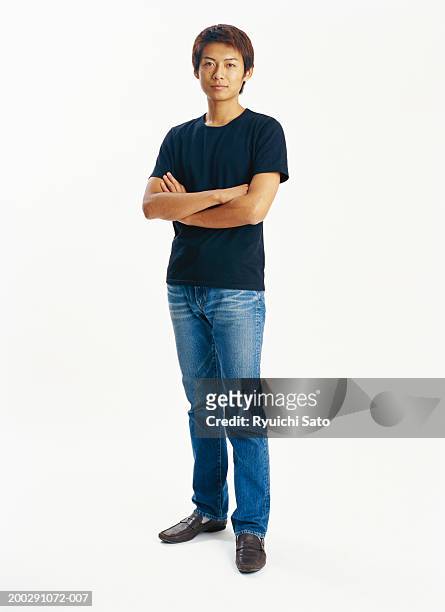 young man standing with arms crossed, portrait - svarta byxor bildbanksfoton och bilder
