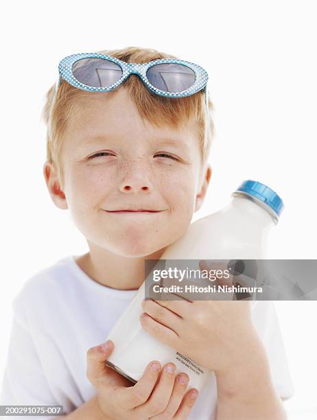 boy (4-5) holding milk bottle, close-up - boy squinting stock pictures, royalty-free photos & images