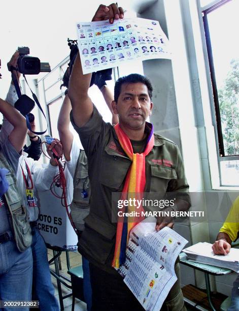 The presidential candidate of Ecuador, colonel Lucio Gutierrez, shows his vote to the press before he puts it in the ballot box, in Quito, 20 October...