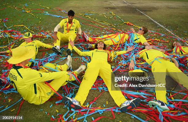 Sam Konstas of Australia celebrates with teammates as they lie on the floor in a pile of confetti as they celebrate after defeating India during the...