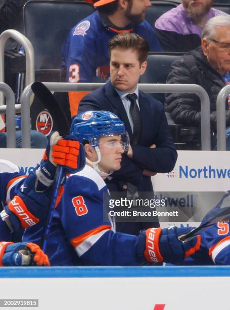 New York Islanders assistant coach Benoit Desrosiers works the bench during the game against the Calgary Flames at UBS Arena on February 10, 2024 in...