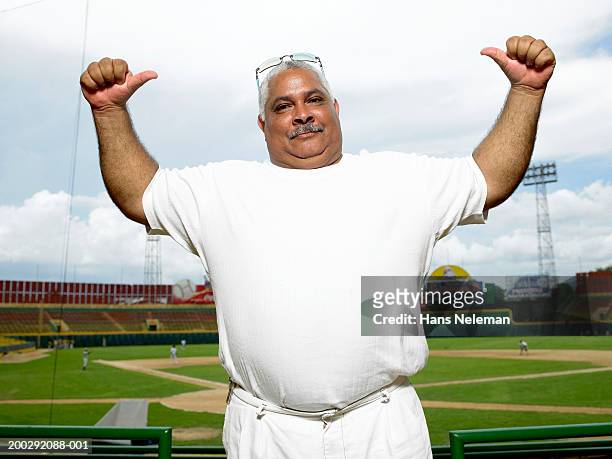 mature man pointing to self in baseball stadium, portrait - baseball tee stock pictures, royalty-free photos & images