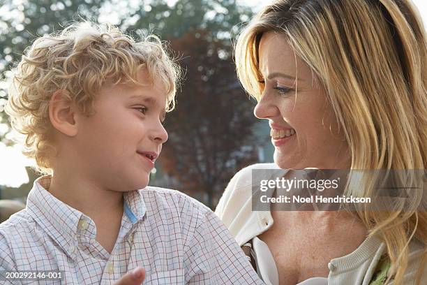 mother smiling at son (5-7 years) outdoors, close-up, side view - 6 7 years stock-fotos und bilder