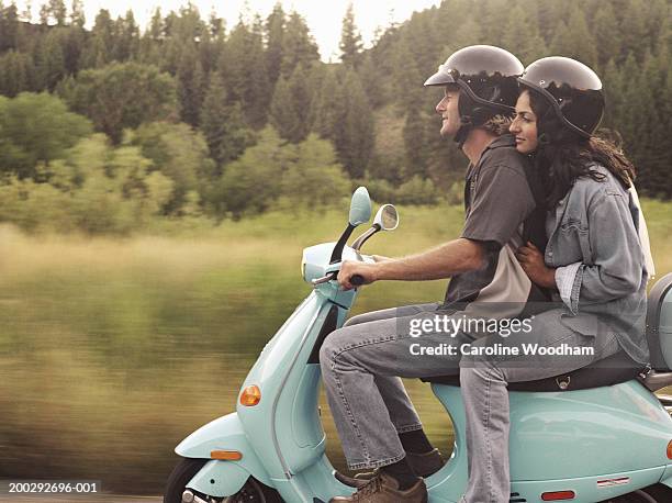 man and young woman riding on motor scooter, side view - motorized vehicle riding stock pictures, royalty-free photos & images