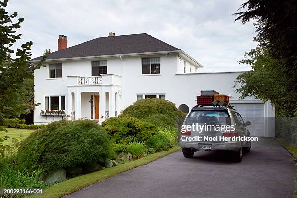 sports utility vehicle parked in front drive of house, loaded with luggage - car in driveway stock-fotos und bilder