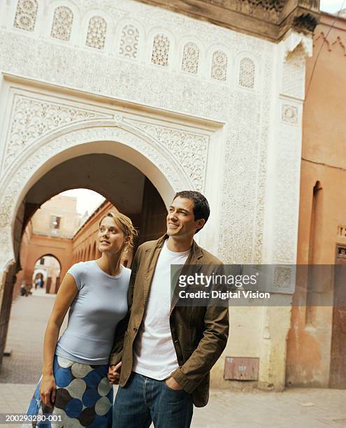 couple holding hands outdoors, smiling - norte africano imagens e fotografias de stock