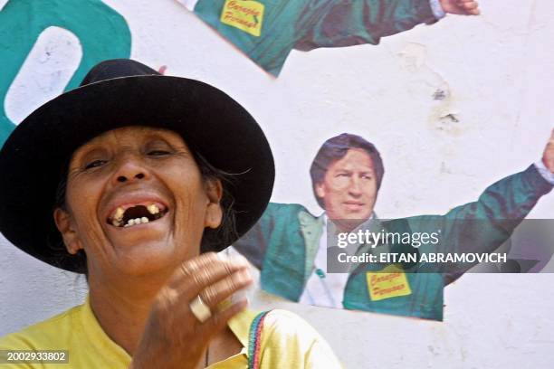 Supporter of Alejandro Toledo, presidential candidate for Peru Possible, laught near a poster of Toledo 05 April 2001 in Lima. Una simpatizante de...