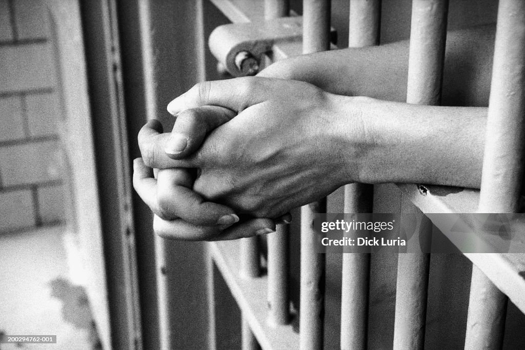 Hands in prison cell