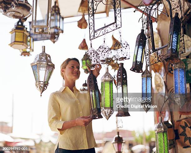 young woman looking at lamp shades in shop - marrakesh imagens e fotografias de stock