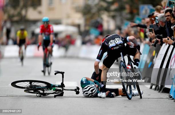 Alex Jaime of Spain and Team Equipo Kern Pharma after being involved in a crash at finish line is assisted by Alexander Krieger of Germany and Tudor...