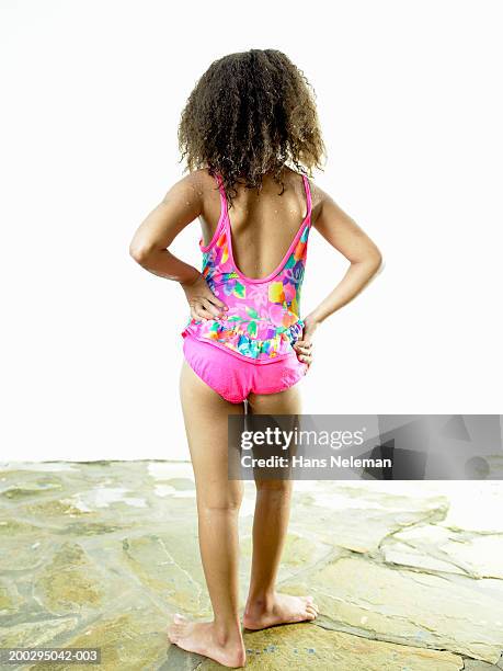 girl (6-8) in bathing suit with hands on hips, rear view - girl who stands stock pictures, royalty-free photos & images