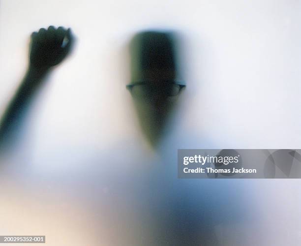 silhouette of man knocking on frosted glass door (backlit) - frosted glass ストックフォトと画像