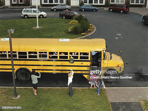 mothers waving to children (6-9) in schooolbus, elevated view - school district stock pictures, royalty-free photos & images