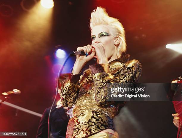 woman singing into microphone, low angle view - blonde female singers stock-fotos und bilder