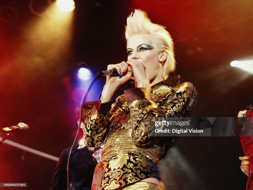 Woman singing into microphone, low angle view