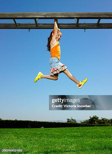 girl (4-6) hanging from monkey bars - monkey bars stock pictures, royalty-free photos & images