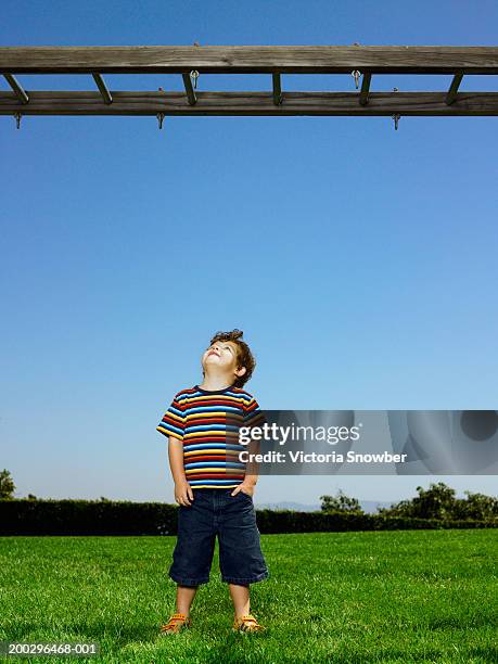 boy (3-5) looking up at monkey bars - monkey bars stock pictures, royalty-free photos & images