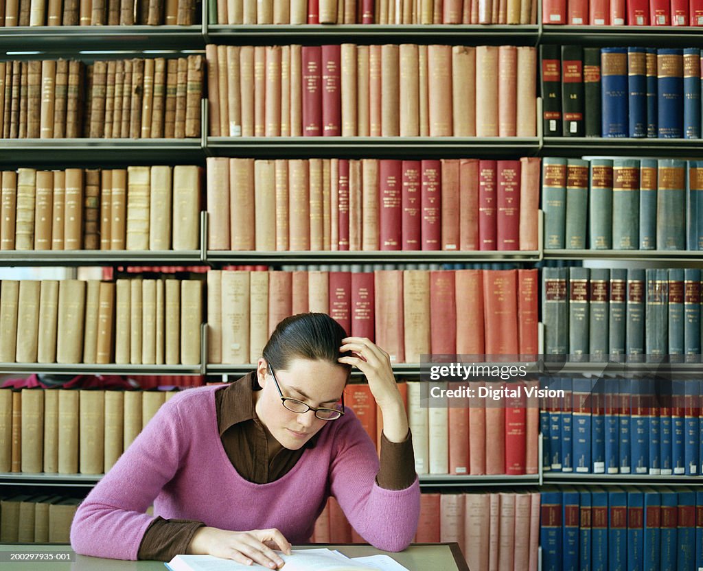 Young woman sitting at table in library