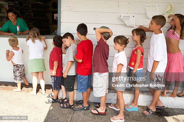 children (2-9) queuing at tuck shop window - kids lining up stock pictures, royalty-free photos & images