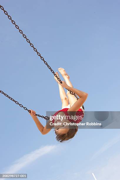 girl (8-10) playing on swing, swinging upside down, portrait - andar de baloiço imagens e fotografias de stock