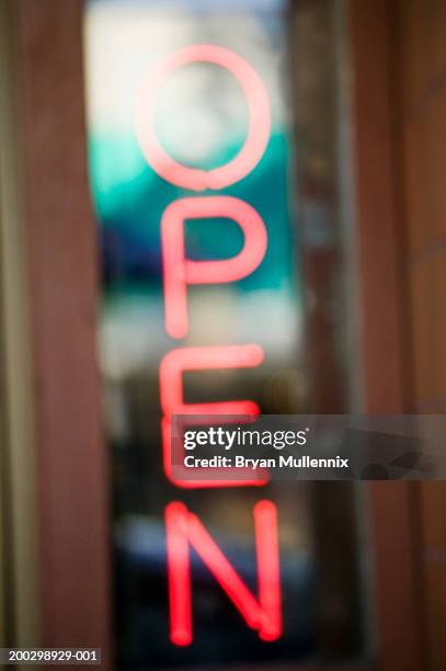 neon 'open' sign in retail store window (defocused) - neon open sign stock pictures, royalty-free photos & images