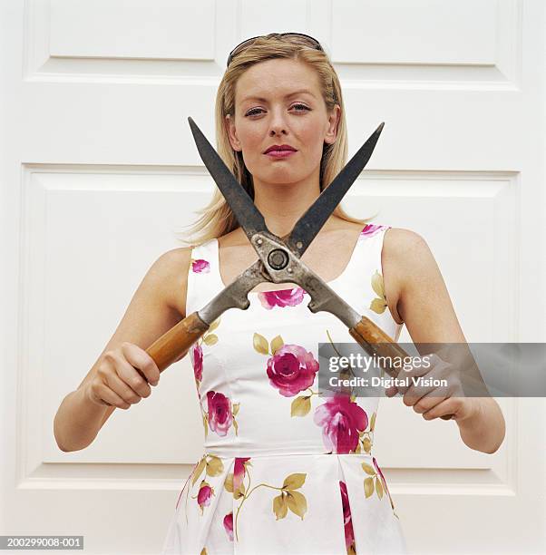 young woman holding garden shears, portrait - heckenschere stock-fotos und bilder