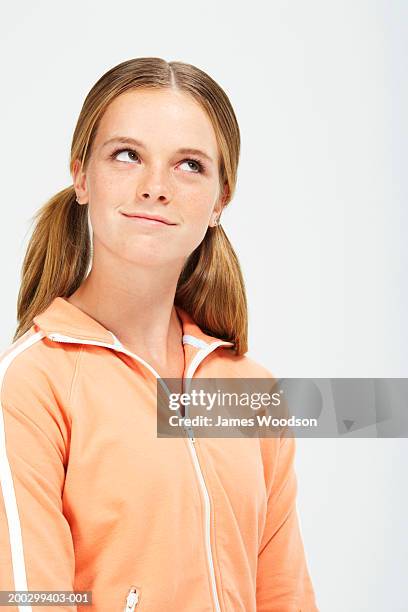 teenage girl (13-15) with hair in bunches, looking up, close-up - james blondes stockfoto's en -beelden