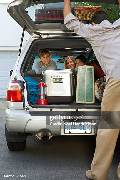 mother with boy and girl (8-13 years) in car, father closing boot lid - closing car boot fotografías e imágenes de stock