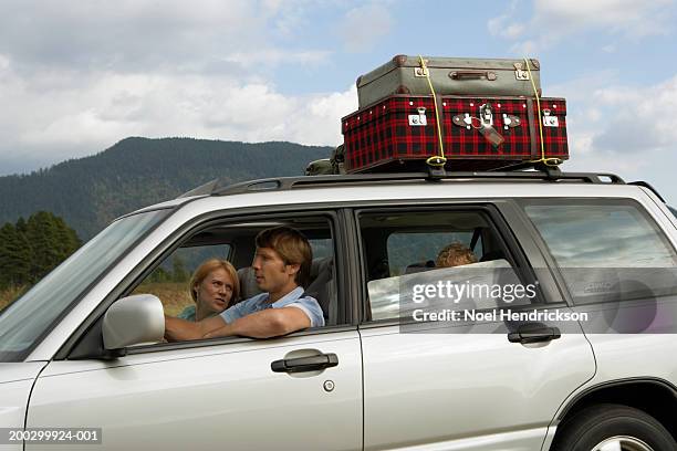 couple driving car, side view, mother looking over shoulder to son (5-7 years) in rear seat - open day 5 stockfoto's en -beelden