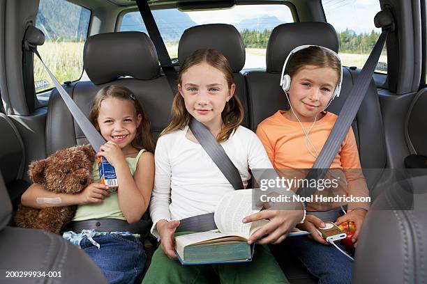 three girls (6-8 years) sitting on rear seat of car, smiling, portrait - kind teddy sitzt stock-fotos und bilder