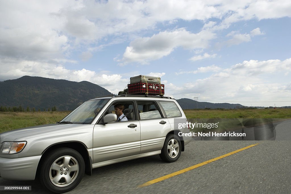 Couple driving sports utility vehicle on rural road