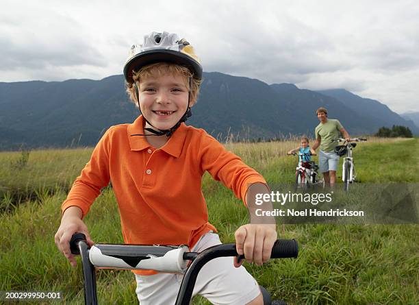 boy (5-7 years) on mountain bike, smiling, portrait, close-up - tothless boys stock-fotos und bilder