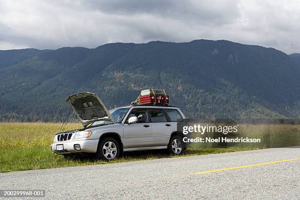 sports utility vehicle with bonnet open parked beside rural road - avería de coche fotografías e imágenes de stock