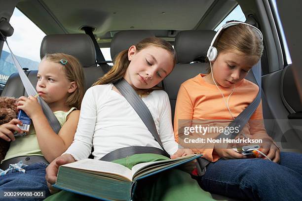 three girls (6-8 years) on rear car seat, close-up - three people in car stock pictures, royalty-free photos & images