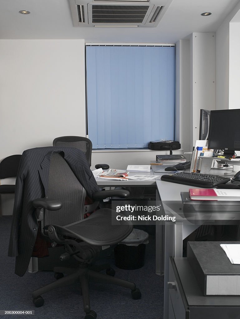 Jacket on chair by desk in office