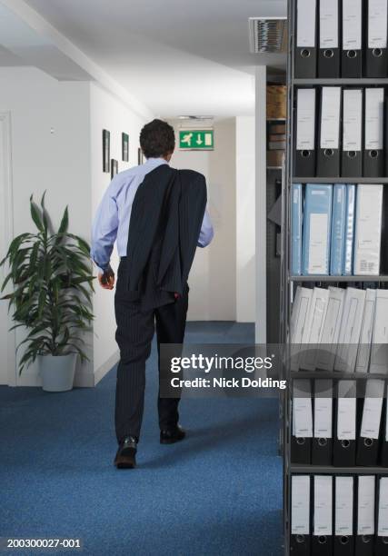 businessman walking in office, jacket over one shoulder, rear view - leaving office stock pictures, royalty-free photos & images