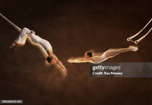 trapeze artist's, woman stretching for man's hands (digital composite) - trapeze artist stock pictures, royalty-free photos & images