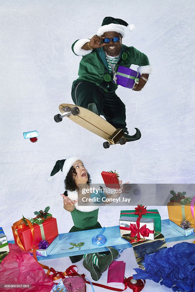 Elf playing on skateboard above female elf at present wrapping station